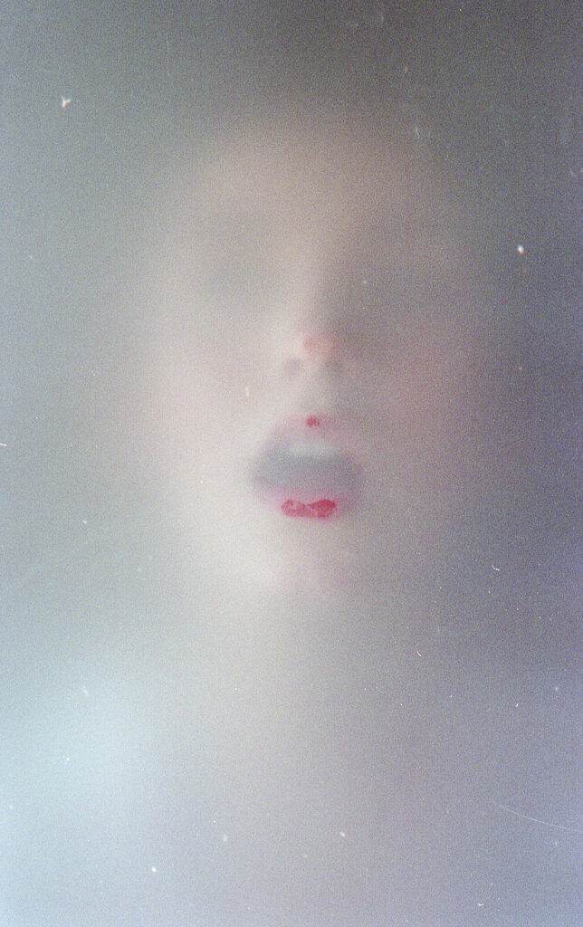 Film Photo of Miranda Valdez a model with a soft focus and a blurred background capturing her face and lips in detail.